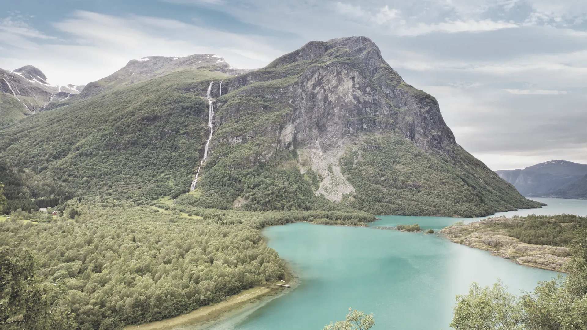 Ein stiller Bergsee, dessen Oberfläche die Hänge ringsum spiegelt