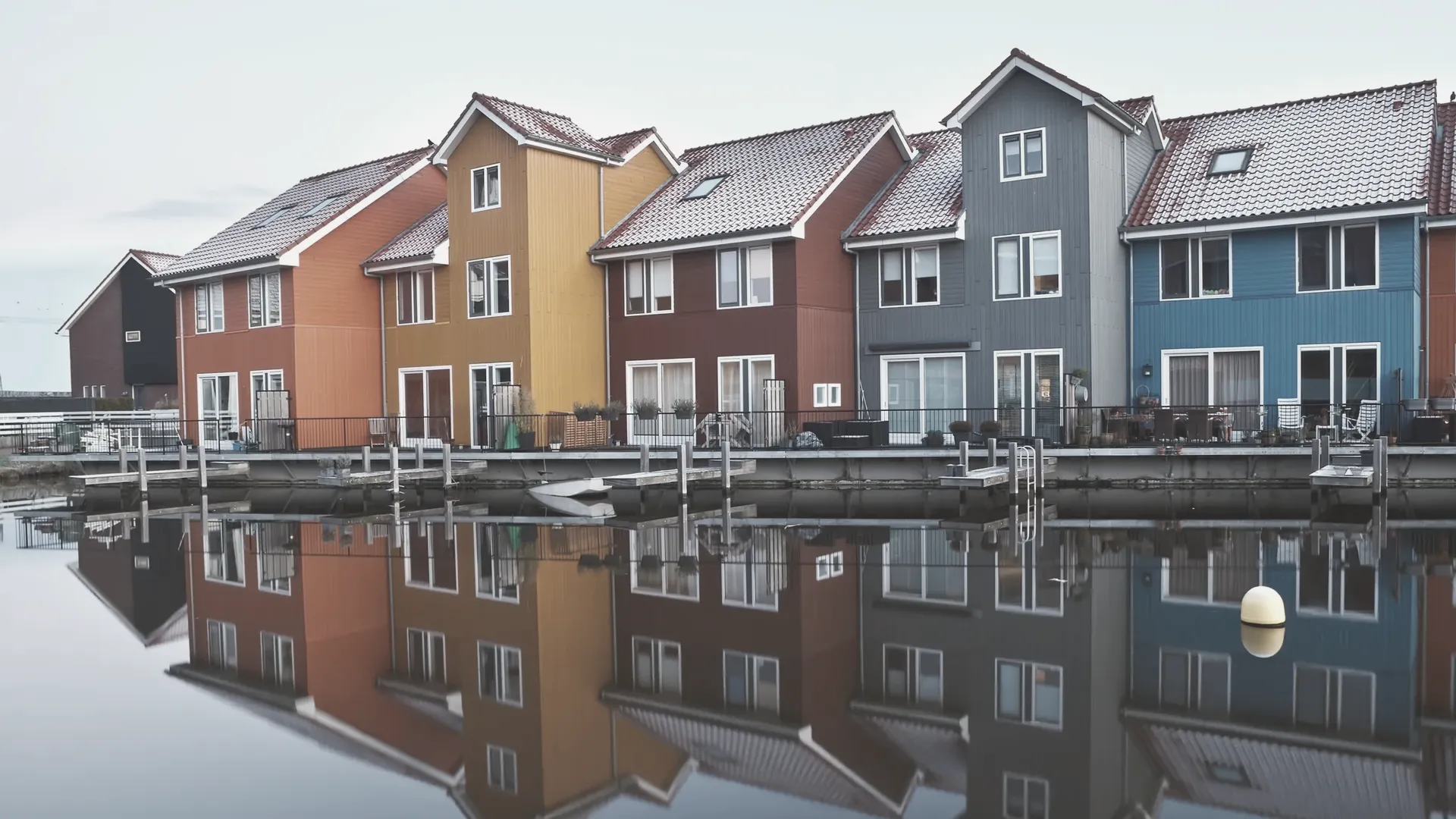 Häuser, die sich in völlig stillem Wasser spiegeln